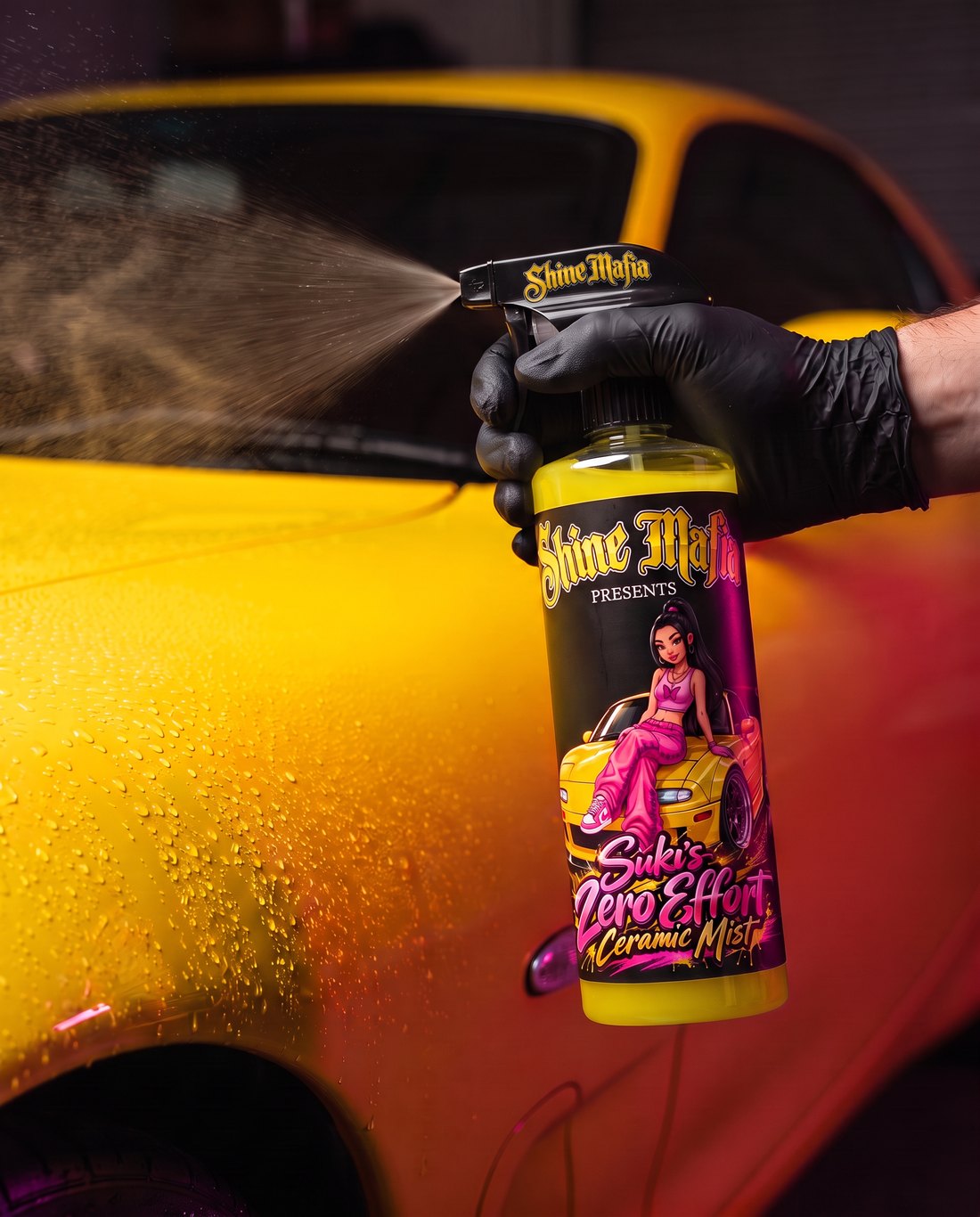 A gloved hand spraying Suki's ceramic mist on yellow paint
