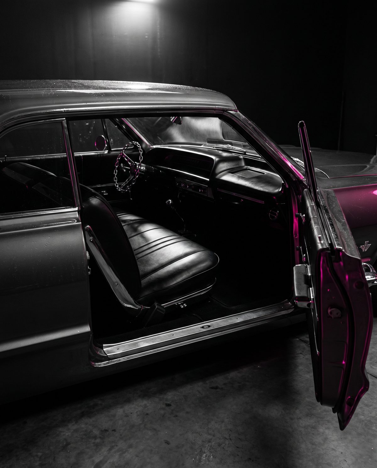 The open door and black bench seat of a lowrider